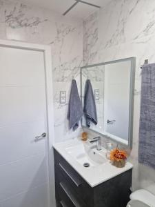 uma casa de banho branca com um lavatório e um espelho em Urbanización la marina San Fulgencio 17 em San Fulgencio