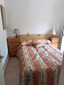 um quarto com uma cama, uma cómoda e um candeeiro em Urbanización la marina San Fulgencio 17 em San Fulgencio