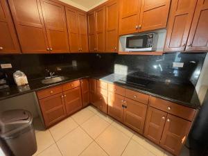 a kitchen with wooden cabinets and a microwave at Suite Condominios Posada frente al mar, San Carlos Reservaciones 212 in San Carlos
