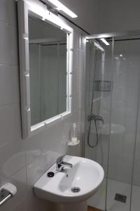 a white bathroom with a sink and a shower at Disan 3B in Portonovo +23 photos