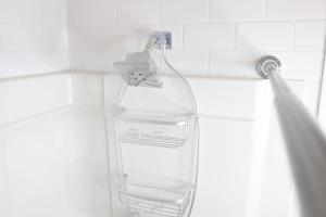a shower head with a clear glass bottle hanging from it at LOCATION LOCATION LOCATION IMMACULATE 1 BEDROOM SUITE in Victoria +88 photos