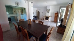 ein Esszimmer mit einem Holztisch und Stühlen in der Unterkunft Casa dos Amigos - NEW management in Estói