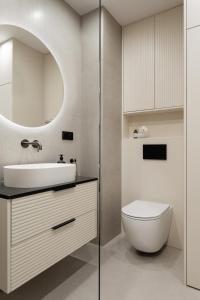 a bathroom with a sink and a toilet and a mirror at Stary Tartak nad jeziorem Drwęckim - MAZURIA APARTAMENTY in Ostróda +26 photos