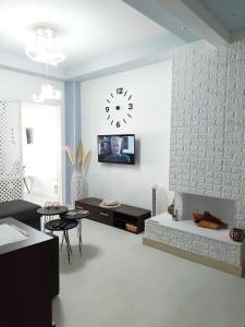 a living room with a clock on the wall at Niko's Apartment - Beautiful Sea View Apartment ! in Perea