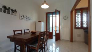 Il comprend une cuisine et une salle à manger avec une table et des chaises en bois. dans l'établissement SeaGarden Apartment, à Livourne
