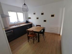 a kitchen with a table and chairs and a sink at Logement Soulac-sur-mer 4 personnes in Soulac-sur-Mer