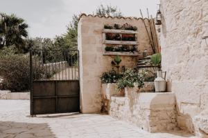 Una puerta con un montón de macetas. en Agriturismo Balcone Mediterraneo - Camere, en Ragusa