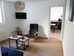 a living room with a chair and a table at Logement Soulac-sur-mer 4 personnes in Soulac-sur-Mer +1 photo