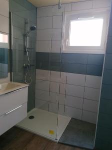 a bathroom with a shower and a sink and a window at Logement Soulac-sur-mer 4 personnes in Soulac-sur-Mer