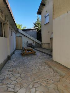 a picnic table in a courtyard between two buildings at Logement Soulac-sur-mer 4 personnes in Soulac-sur-Mer