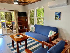 a living room with a blue couch and a table at VeLento Partial Ocean View #6 in Caye Caulker