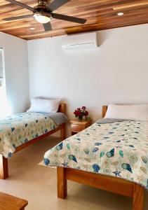 - une chambre avec 2 lits et un ventilateur de plafond dans l'établissement VeLento Partial Ocean View #6, à Caye Caulker