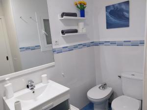 uma casa de banho branca com um lavatório e um WC em APARTAMENTO con TERRAZA VISTAS AL MAR em Lloret de Mar