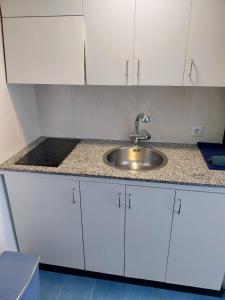 d'un comptoir de cuisine avec un évier et des placards blancs. dans l'établissement APARTAMENTO con TERRAZA VISTAS AL MAR, à Lloret de Mar