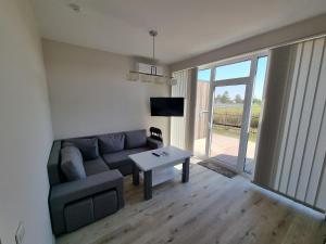 a living room with a couch and a table at Kotedžai Ąžuolo Istorija 9 in Palanga