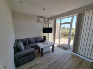 a living room with a couch and a table at Pajūrio Ąžuolo Istorija 9 in Palanga