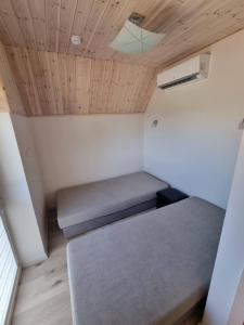 een kleine kamer met een bed en een plafond bij Kotedžai Ąžuolo Istorija 9 in Palanga