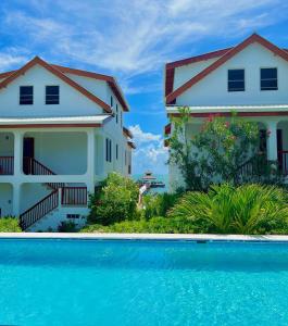 a house and a swimming pool in front of a house at VeLento Oceanfront Penthouse #1 in Caye Caulker