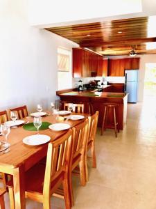 uma sala de jantar com uma mesa de madeira e uma cozinha em VeLento Oceanfront Penthouse #3 em Caye Caulker