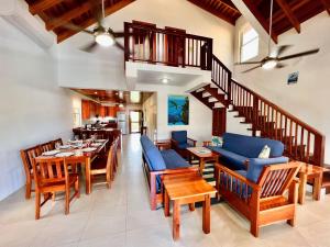 a dining room with chairs and tables and a staircase at VeLento Oceanfront Penthouse #3 in Caye Caulker