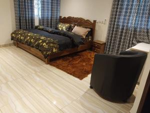 a bedroom with a bed and a flat screen tv at EuChris Homes in Kumasi