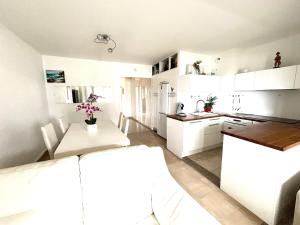 Una cocina con gabinetes blancos y una mesa. en 2p front de mer bocca cabana, en Cannes