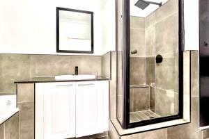 a bathroom with a sink and a shower at Sandton Lux, 2 Bedroom & 2 Ensuite, No Load shedding in Johannesburg +10 photos