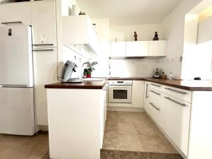 Una cocina con gabinetes blancos y un refrigerador blanco. en 2p front de mer bocca cabana, en Cannes