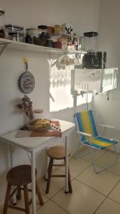 een keuken met een witte tafel en 2 stoelen bij Loft Individual Aconchegante in Rio Grande