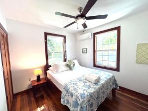Un dormitorio con una cama y un ventilador de techo. en Barbara's Beach House, en Caye Caulker 17 fotos más
