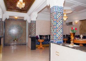 eine Lobby mit einer großen Wand und einem Zimmer mit einem Sofa in der Unterkunft Luxury Fes Villa in Fès
