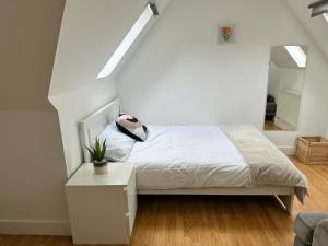 a white bedroom with a bed and a staircase at Wembley Stadium Serviced Apartments, 12mins to Central London in London