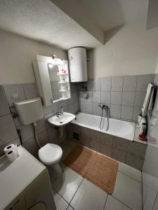 a bathroom with a toilet and a tub and a sink at GOLD APARTMENT in Berane