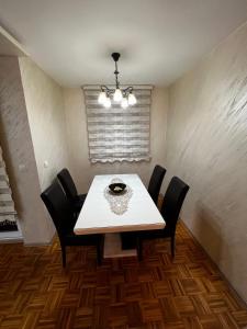 a dining room with a white table and black chairs at GOLD APARTMENT in Berane