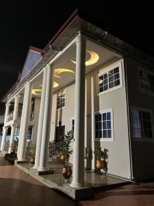 ein großes weißes Haus mit Säulen und Lichtern drauf in der Unterkunft EuChris Homes in Kumasi