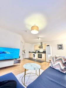 a living room with a blue couch and a kitchen at Unique and luxury city center apartment with free parking in Southampton