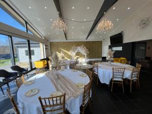 a dining room with white tables and chairs and chandeliers at Luxry Villa in Pottum in Pottum