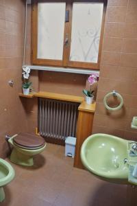 a bathroom with a green toilet and a sink at Dolce vita Assisi flat two bedrooms two bathrooms in Assisi