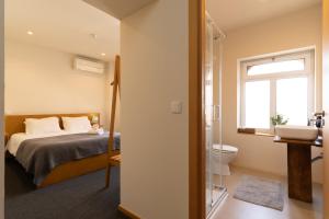 1 dormitorio con 1 cama y baño con lavamanos en Peach Hostel & Suites, en Oporto