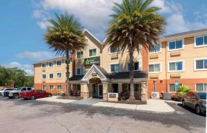 un hôtel avec des palmiers dans un parking dans l'établissement Extended Stay America Select Suites - Jacksonville Salisbury Rd Southpoint, à Jacksonville