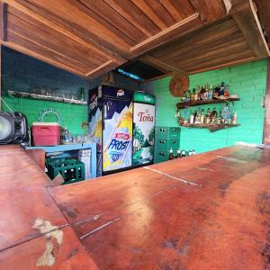 a large wooden bar in a room with a green wall at La Cascada Hostel & Restaurant in Rivas +56 photos