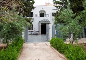 a white house with a gate and a driveway at Luxury Fes Villa in Fez