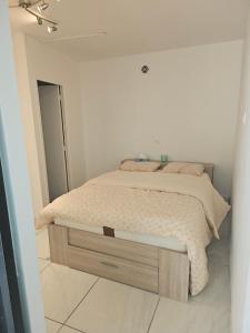 - une chambre blanche avec un lit dans l'établissement KIFKIF, à Saint-Germain-lès-Arpajon
