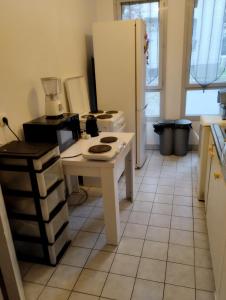 een keuken met een witte tafel en een koelkast bij Cozy chambre en Clichy, tout près de Paris in Clichy