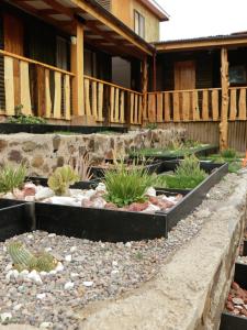 un jardin avec des rochers et des plantes devant une maison dans l'établissement Hotel y Restaurant Doña Rode, à Andacollo
