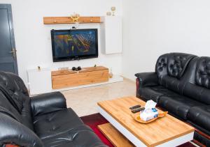 salon z 2 skórzanymi kanapami i telewizorem w obiekcie Luxury Fes Villa w Fezie