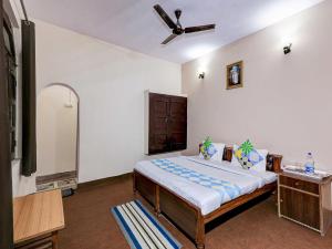 sypialnia z łóżkiem i wentylatorem sufitowym w obiekcie OYO Flagship Adhya Inn w mieście Nainital