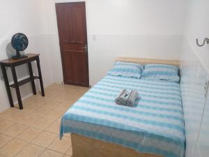 ein Schlafzimmer mit einem Bett mit einem Paar Schuhe darauf in der Unterkunft Hotel Primu's in Novo Airão
