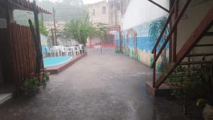 a swimming pool in a building with a mural at Pousada Maria Bonita in Paripueira