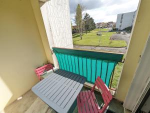 2 sillas y una mesa en un balcón con ventana en 3 Chambres chez l'Habitant en Face du CHU et de l'Université de Poitiers en Poitiers